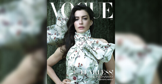 A woman in a floral, high-neck dress poses in front of a dark green backdrop on the cover of Vogue magazine, with the headline "FEARLESS!" and the name Anne Hathaway featured prominently.