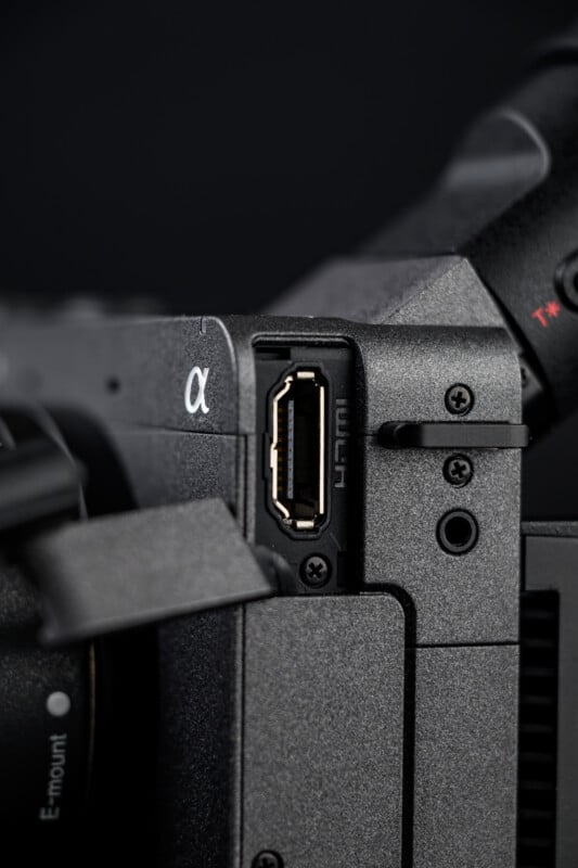 Close-up of an HDMI port on a black Sony Alpha series camera, showing detailed texture and part of the camera body, with the Alpha logo visible on the left.