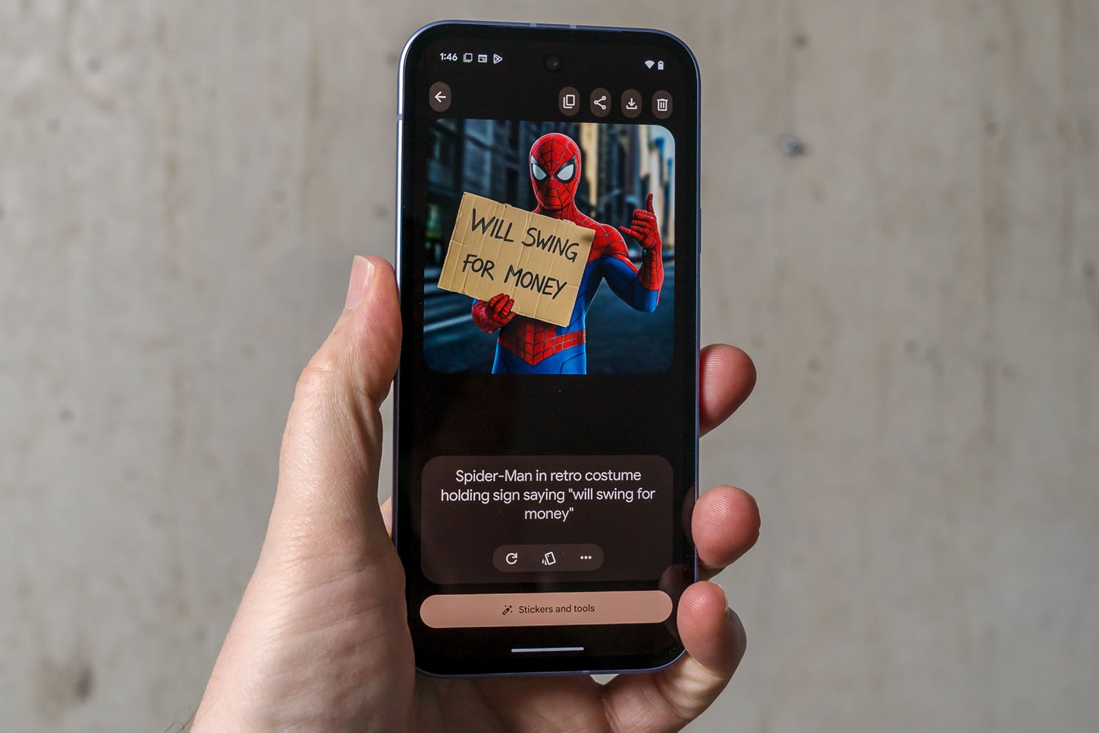A hand holds a smartphone displaying a photo of someone in a Spider-Man costume holding a cardboard sign that reads, "Will swing for money.