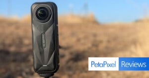 A close-up of the Insta360 One X2 camera is captured outdoors with a blurred, dry landscape in the background. The image features the "Petapixel Reviews" logo in the bottom right corner.