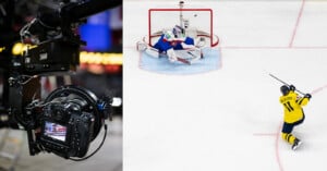 Close-up of a professional camera capturing a hockey game; next to it, a hockey player in yellow shoots the puck towards the goal as the opposing goalie makes a save attempt on the ice.
