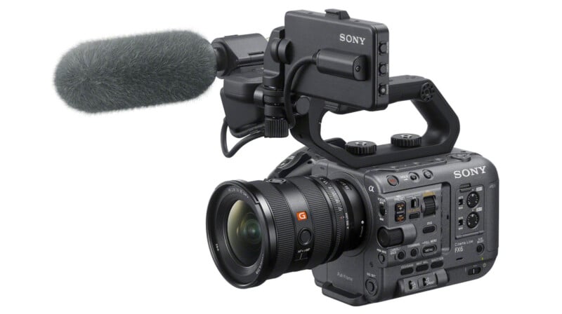 A professional Sony video camera with a large lens, built-in handle, external microphone, and numerous control buttons is shown on a white background.