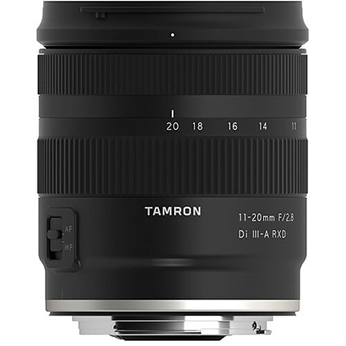 A black Tamron 11-20mm F/2.8 Di III-A RXD camera lens shown upright, with visible focus and zoom rings, and an AF/MF switch on the side. The lens mount is facing downward.