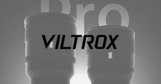 Two camera lenses labeled "Pro" are shown side by side with the word "VILTROX" prominently overlaid across the image. The background is gray with large, faded letters reading "Pro.